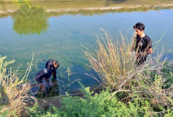 KANALDAN ÇIKARILAN OĞLUNUN CANSIZ BEDENİNİ KUCAĞINDA TAŞIDI