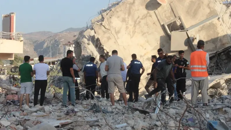 Antakya’da yıkım çalışması sırasında çöken binanın altında kalan iş makinesi operatörü kurtarıldı